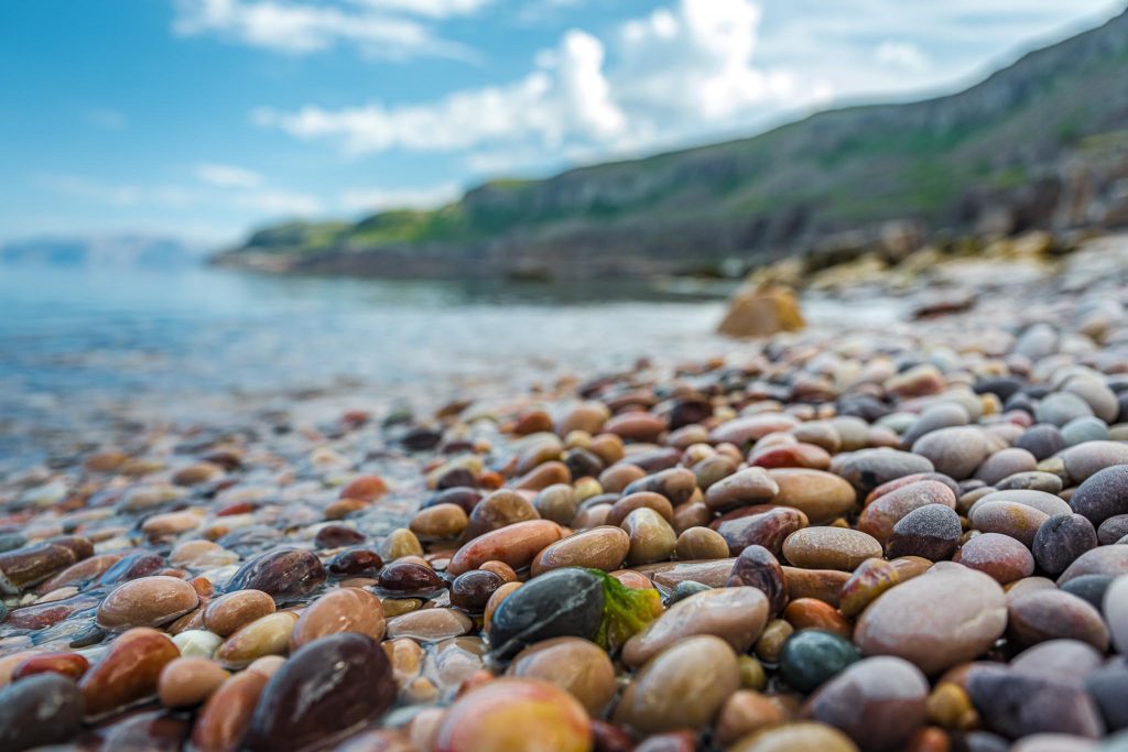 Värikkäitä kiviä rannalla.